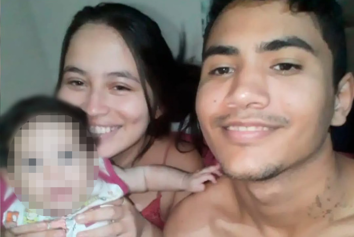 Young couple smiling with a blurred baby, related to a pregnant woman on life support sparking debate. Young couple smiling with a blurred baby, related to a pregnant woman on life support sparking debate.