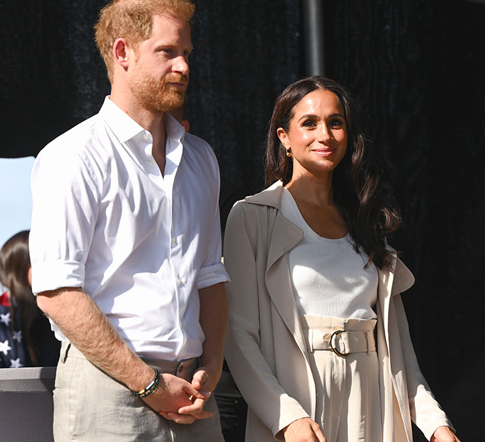 Prince Harry and Meghan Markle standing outdoors, engaging with LA fire victims. Prince Harry and Meghan Markle standing outdoors, engaging with LA fire victims.