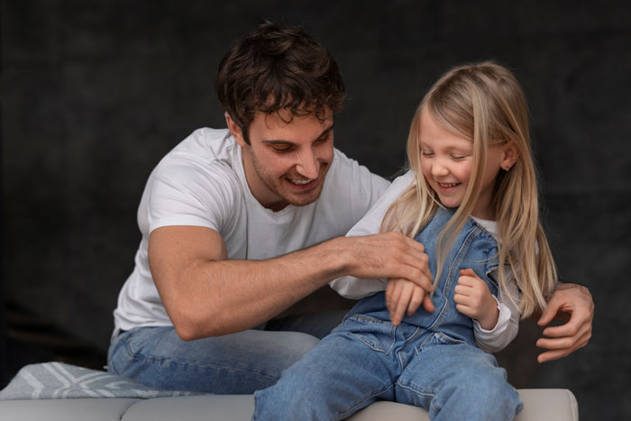Man in casual wear playing with stepchild, highlighting hobbies and family dynamics. Man in casual wear playing with stepchild, highlighting hobbies and family dynamics.
