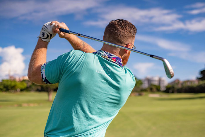 Man swinging a golf club on a sunny day, focusing on hobbies. Man swinging a golf club on a sunny day, focusing on hobbies.