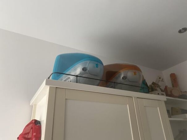 Retro finds: two vintage iMac computers, blue and orange, on top of a cabinet, evoking nostalgia for the good old days.