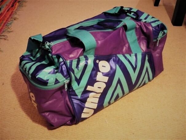 Retro Umbro duffel bag in purple and green on a carpet, evoking nostalgic memories of the past.