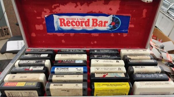 Retro finds: a collection of vintage 8-track tapes in a Record Bar case, evoking nostalgia for the good old days.