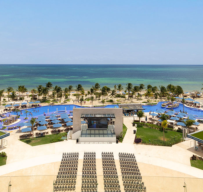 Aerial view of a Cancun resort with beachside pool and palm trees. Aerial view of a Cancun resort with beachside pool and palm trees.