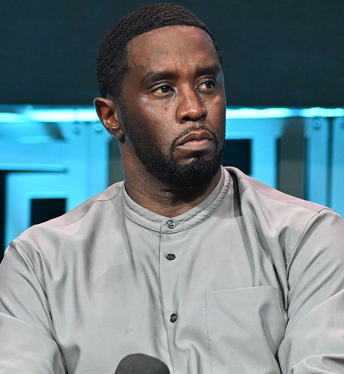 Man in a gray shirt at a public event, related to conspiracy theories surrounding a Palisades fire. Man in a gray shirt at a public event, related to conspiracy theories surrounding a Palisades fire.
