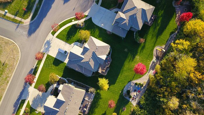 Aerial view of suburban homes with lush green lawns, illustrating strategies to protect your info from scammers. Aerial view of suburban homes with lush green lawns, illustrating strategies to protect your info from scammers.