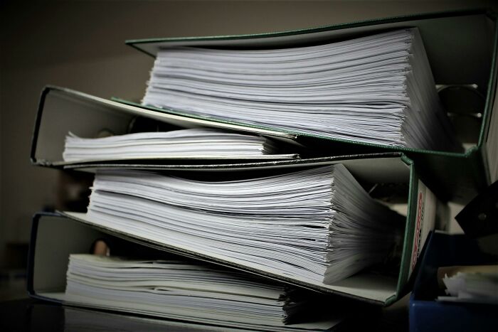 Stack of binders filled with documents to help protect your info against home title hijacking by scammers. Stack of binders filled with documents to help protect your info against home title hijacking by scammers.