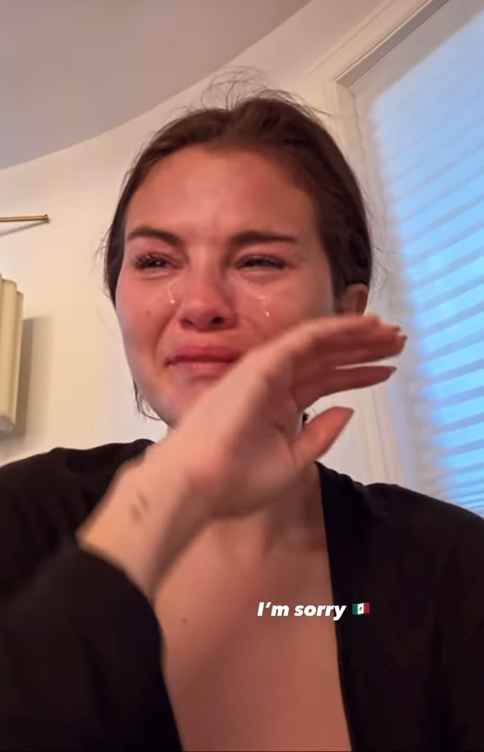 Selena Gomez crying while wiping tears. Selena Gomez crying while wiping tears.