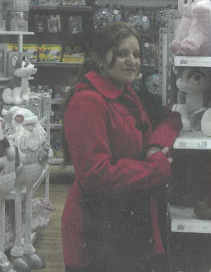 Woman in a red coat stands in a toy store, arranged marriage bride theme. Woman in a red coat stands in a toy store, arranged marriage bride theme.