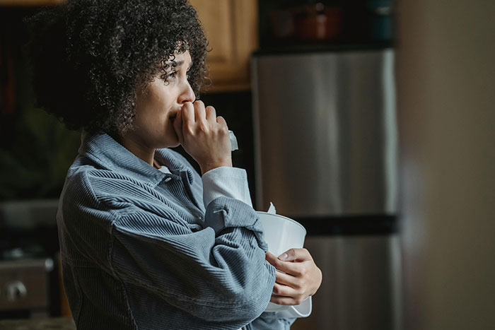 A woman looking pensive in a kitchen, embodying wedding color scheme drama. A woman looking pensive in a kitchen, embodying wedding color scheme drama.