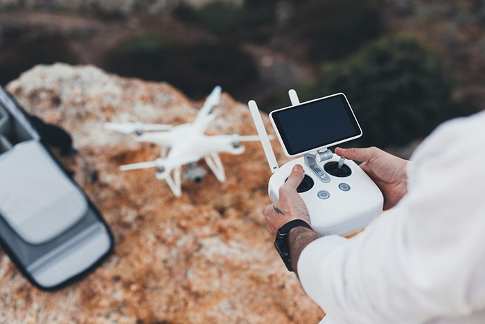Man controlling a drone in rocky terrain, illustrating a successful business venture. Man controlling a drone in rocky terrain, illustrating a successful business venture.