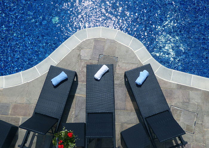 Poolside loungers at a resort with rolled towels; petty revenge setup against selfish people. Poolside loungers at a resort with rolled towels; petty revenge setup against selfish people.