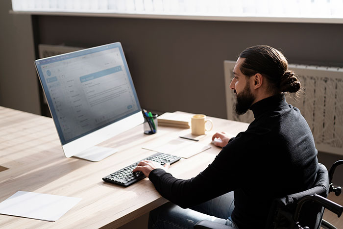 Man with a beard working at a desk with a computer, sipping coffee in an office setting, focused on work tasks. Man with a beard working at a desk with a computer, sipping coffee in an office setting, focused on work tasks.