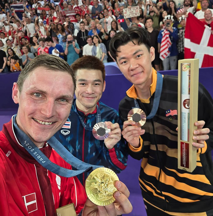 Athletes proudly displaying Paris Olympic medals in a crowded venue. Athletes proudly displaying Paris Olympic medals in a crowded venue.