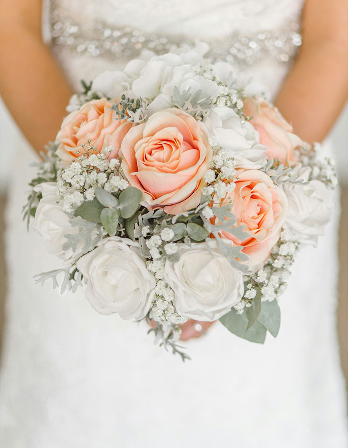 Bride holding a bouquet of pink and white roses; focus on arranged marriage theme. Bride holding a bouquet of pink and white roses; focus on arranged marriage theme.