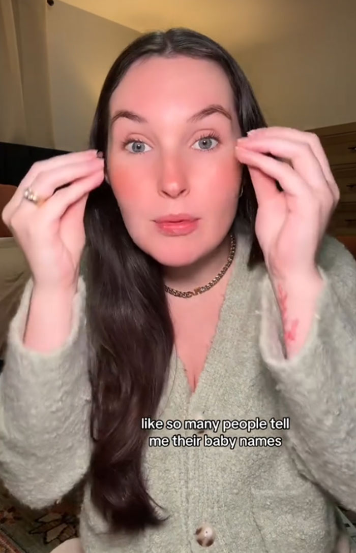 Woman in a cozy sweater, discussing accidentally naming her dog Pearl with the baby's name on screen. Woman in a cozy sweater, discussing accidentally naming her dog Pearl with the baby's name on screen.