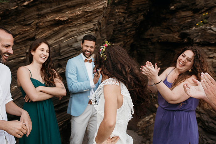Pregnant bride smiling with friends at wedding, wearing a floral crown, with rocks in the background. Pregnant bride smiling with friends at wedding, wearing a floral crown, with rocks in the background.