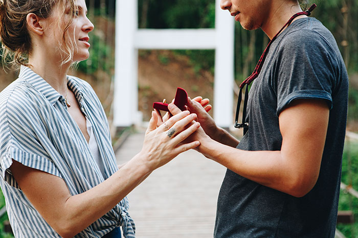 A man proposing to his best friend with a ring in a park setting. A man proposing to his best friend with a ring in a park setting.