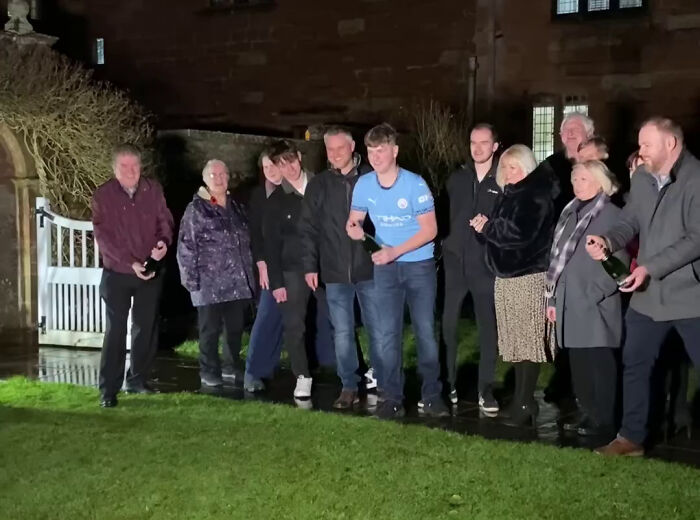 Group celebrating lottery win with champagne bottles, standing in a garden at night. Group celebrating lottery win with champagne bottles, standing in a garden at night.