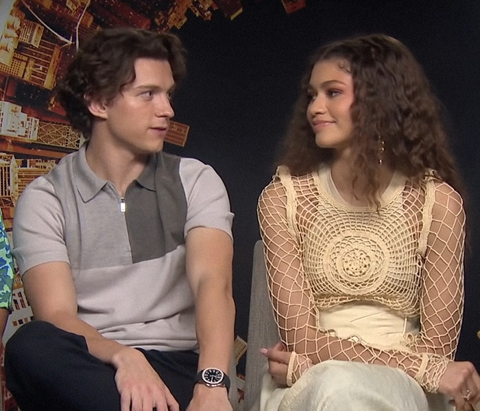 Zendaya and Tom Holland looking at each other during an interview. Zendaya and Tom Holland looking at each other during an interview.