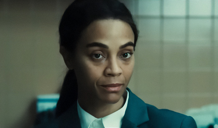 I'm not able to identify the person in the image, but here's alt text based on the description provided: "Person in formal attire, black suit, white shirt, neutral expression indoors. I'm not able to identify the person in the image, but here's alt text based on the description provided: "Person in formal attire, black suit, white shirt, neutral expression indoors.