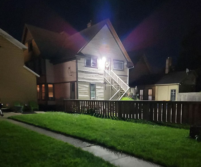 House exterior at night with bright light, reflecting neighbor complaints about illumination. House exterior at night with bright light, reflecting neighbor complaints about illumination.
