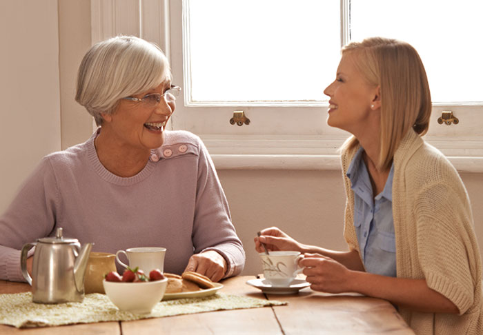 Two women sharing tea and laughter, reflecting on friendship and inheritance discussions. Two women sharing tea and laughter, reflecting on friendship and inheritance discussions.