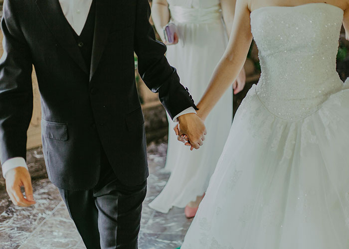 Bride and groom holding hands in wedding attire, symbolizing eloping. Bride and groom holding hands in wedding attire, symbolizing eloping.