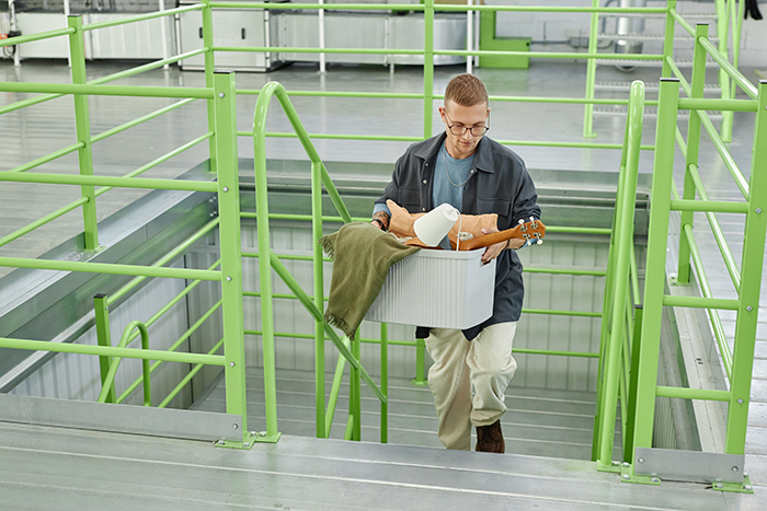 Man carrying items up stairs, planning a lesson in toxic girlfriend revenge, wearing glasses and a jacket. Man carrying items up stairs, planning a lesson in toxic girlfriend revenge, wearing glasses and a jacket.