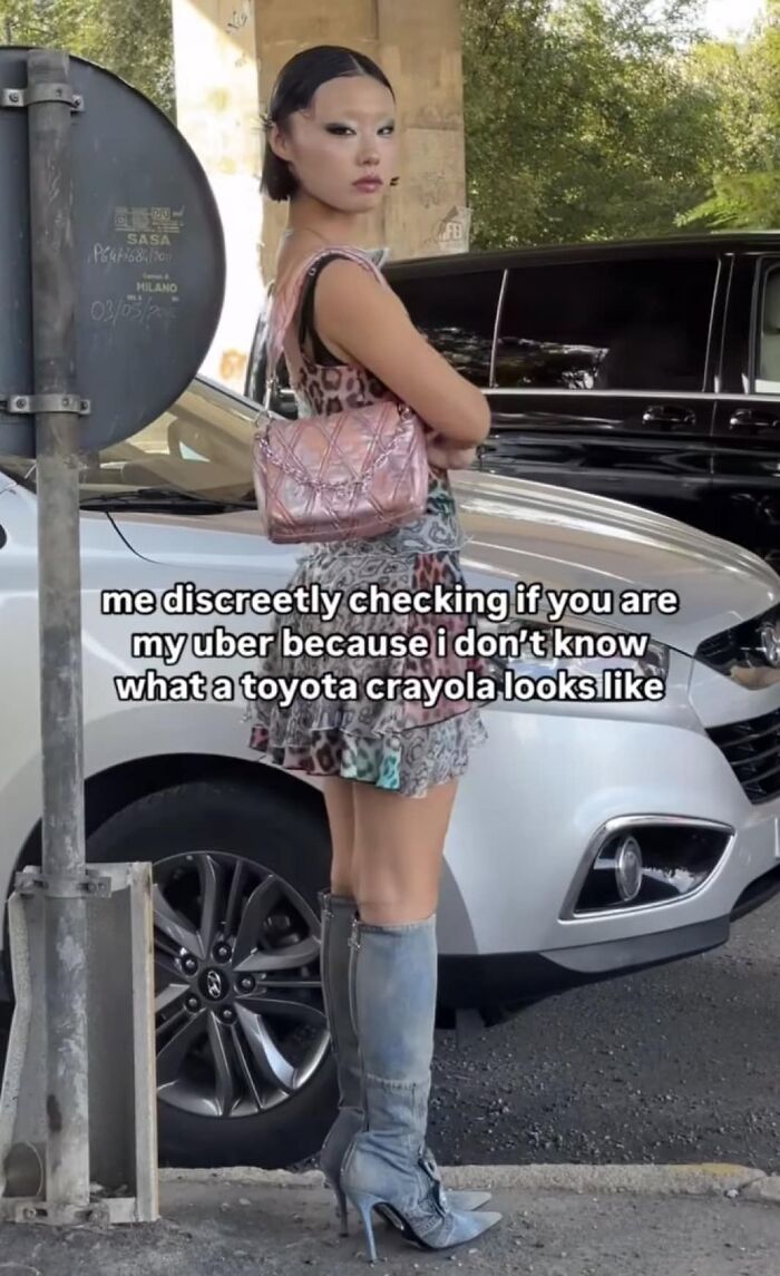 Fashionable person with pink bag and tall boots, humorously checking for Uber, brings a dose of positivity.