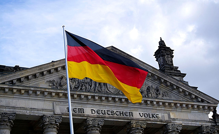 German flag waving in front of historic building, showcasing cultural insights. German flag waving in front of historic building, showcasing cultural insights.
