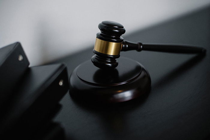 A judge's gavel on a dark table, symbolizing justice related to a woman's ex in a bugged car scenario. A judge's gavel on a dark table, symbolizing justice related to a woman's ex in a bugged car scenario.