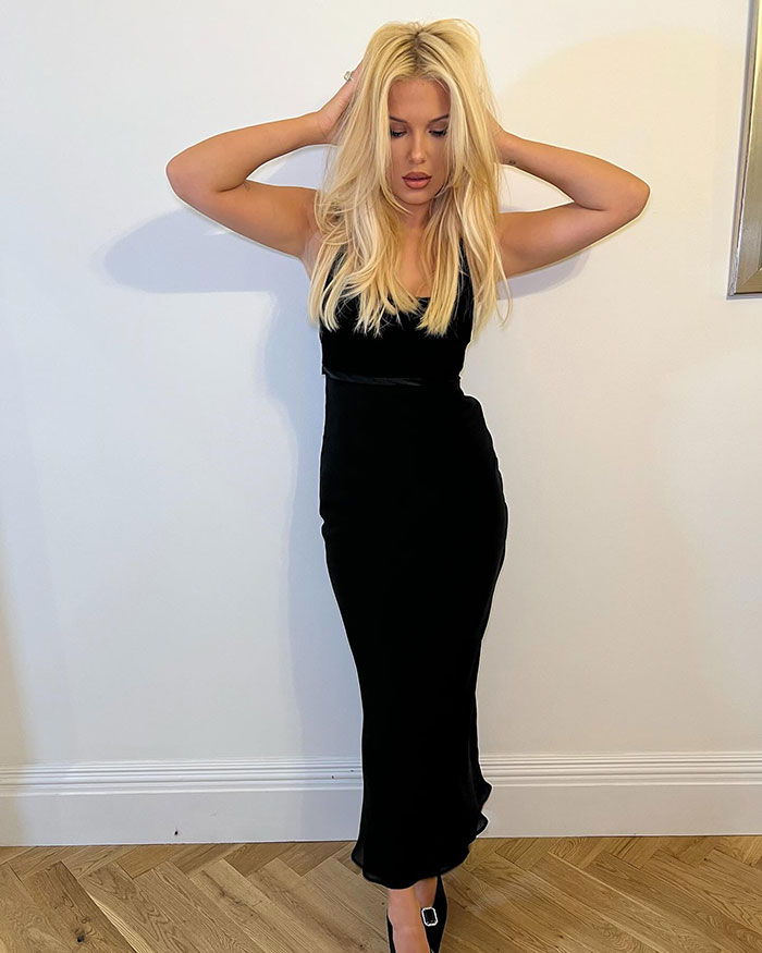 Blonde woman in a sleek black dress, posing with hands on head, showcasing a bold look for her 21st birthday celebration. Blonde woman in a sleek black dress, posing with hands on head, showcasing a bold look for her 21st birthday celebration.