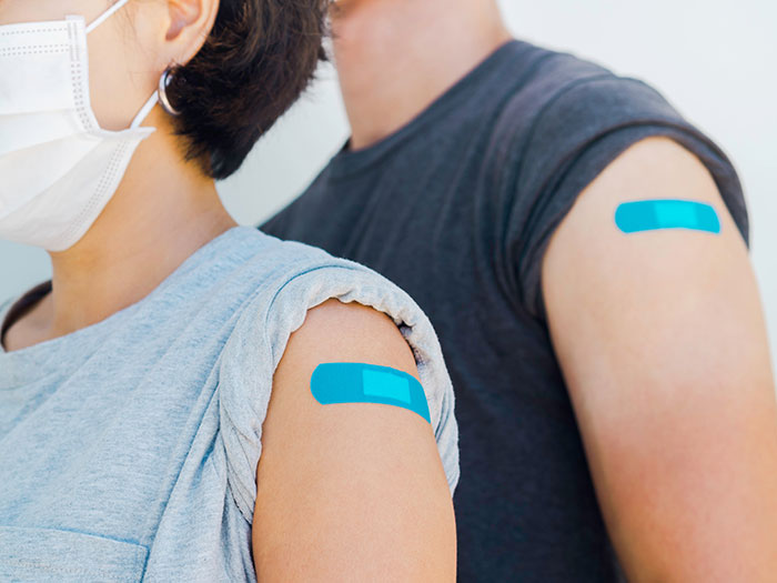 People with band-aids on arms after Covid vaccines. People with band-aids on arms after Covid vaccines.
