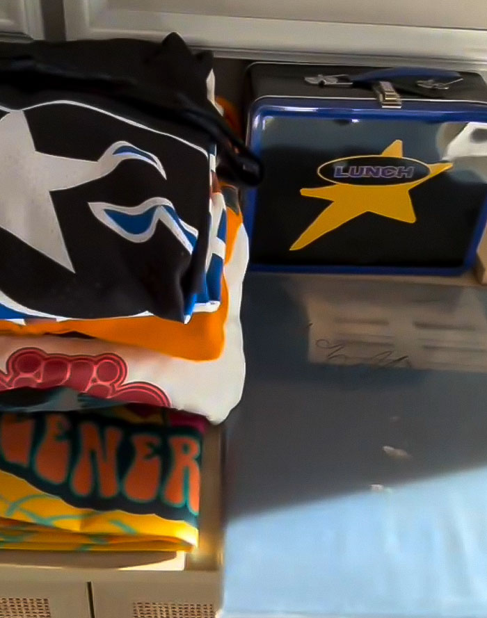 A lunchbox with a star and folded clothes on a table, associated with charity and self promotion. A lunchbox with a star and folded clothes on a table, associated with charity and self promotion.