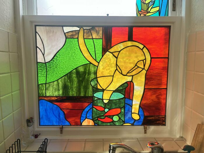 Stained glass window with colorful cat and fish design, showcasing creative DIY project.