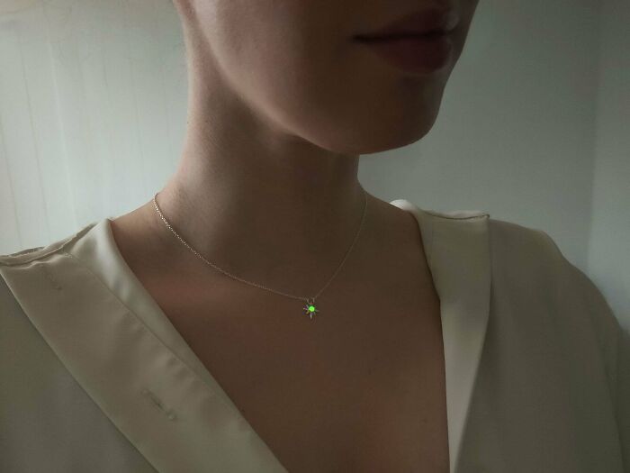 Necklace DIY project with a glowing pendant worn by a person in a light blouse.