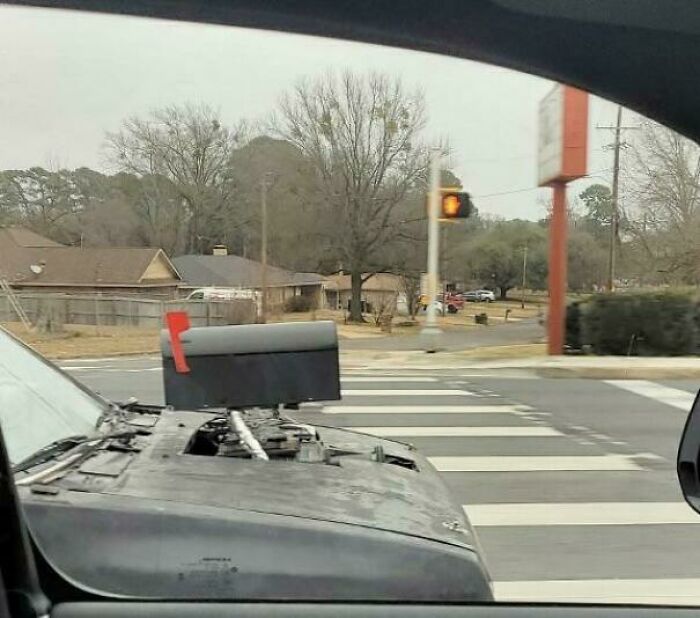 Car with a mailbox mounted on the hood, showcasing a redneck engineer's ingenious and unconventional creation.