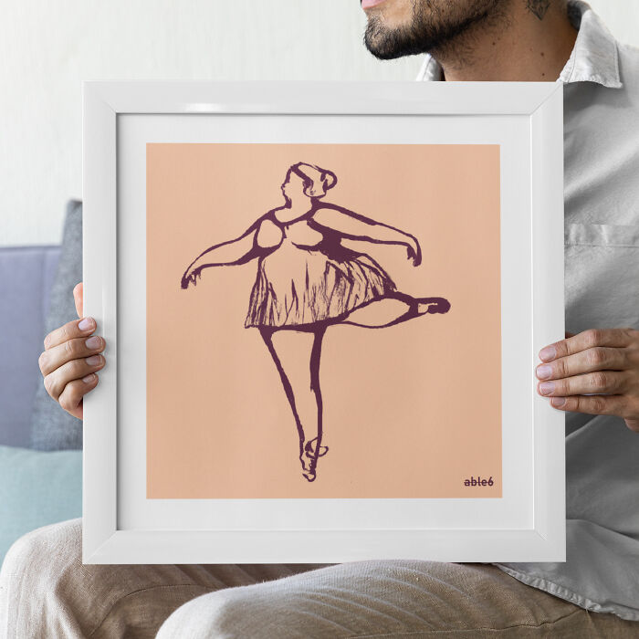 Framed DIY art of a dancer sketch, held by a person in a white shirt.