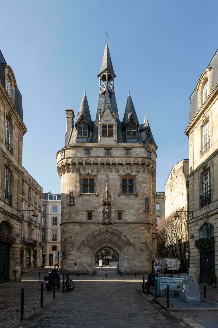 Historic architectural feat with stone tower and spires in European city street, showcasing impressive design and craftsmanship.