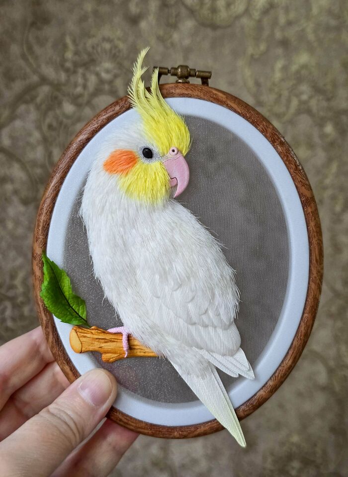 Embroidery art of a white cockatiel in an oval frame, showcasing a creative DIY project.