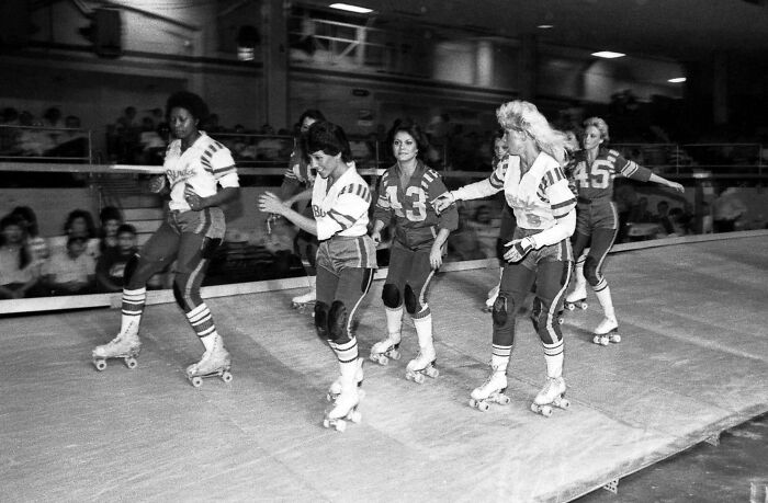 Women roller skating in 1970s uniforms, capturing a nostalgic moment that might make you feel old.
