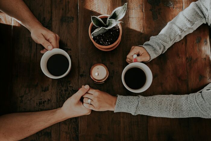Couple holding hands over coffee. Couple holding hands over coffee.