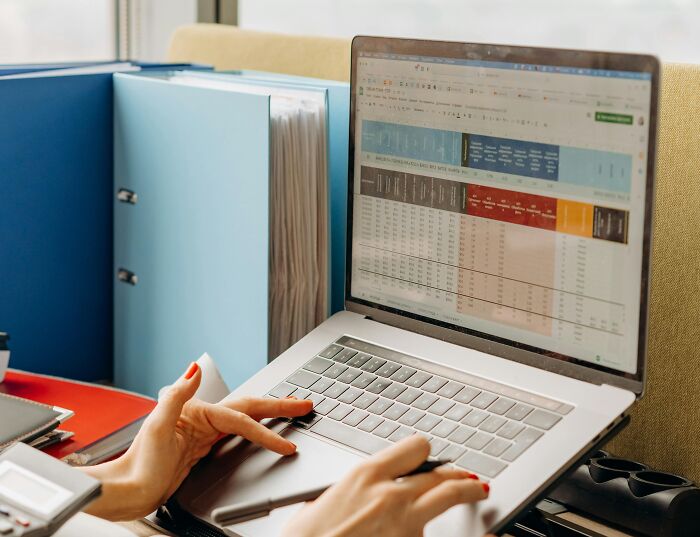 Person analyzing spreadsheet data on a laptop, highlighting work skills people lack in office setting.
