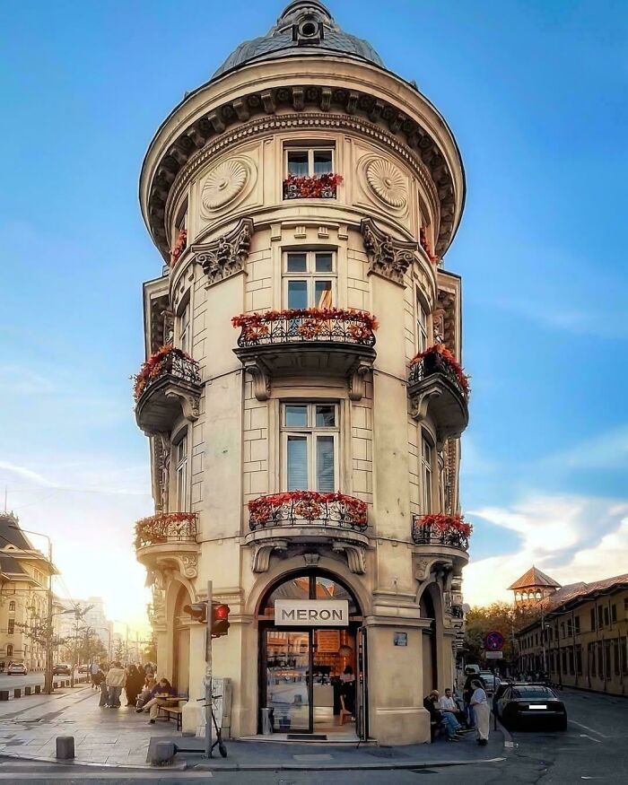 Historic building with ornate balconies and detailed architectural feats under a clear blue sky in an urban setting