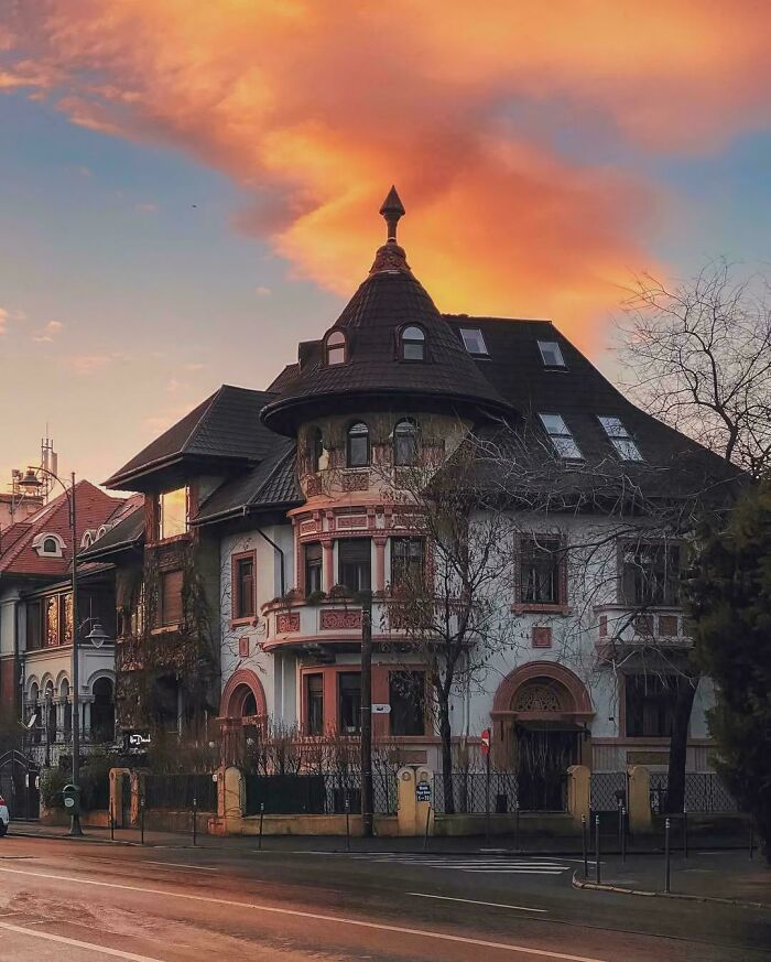 Historic architectural feat featuring a detailed turret and ornate windows under a vibrant sunset sky.