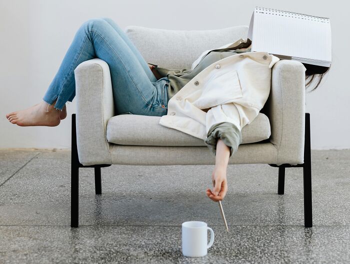 Person on a chair with a book over their face, showcasing a relaxed brilliant-life-hack moment.
