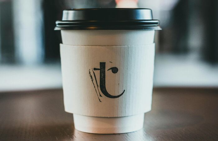 Takeaway coffee cup on a table, featuring creative sleeve design.