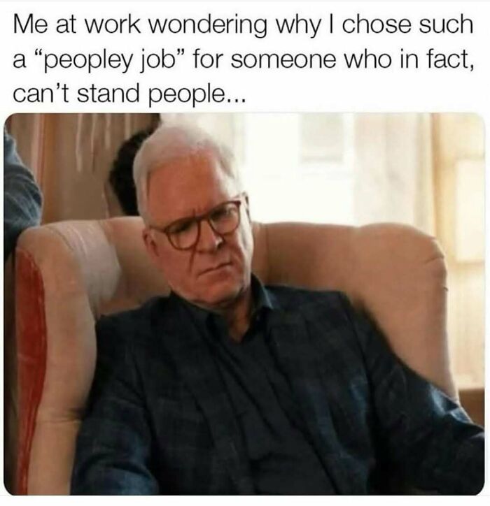 Man with glasses sitting in chair looking confused, representing humor as a coping mechanism in a people-focused job.