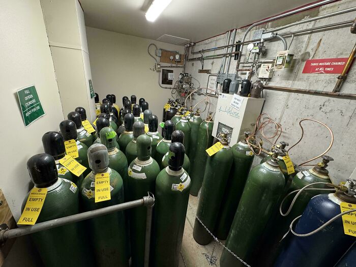 Room filled with gas cylinders stored unsafely, highlighting employees ignoring safety protocol and hazardous workplace decisions.